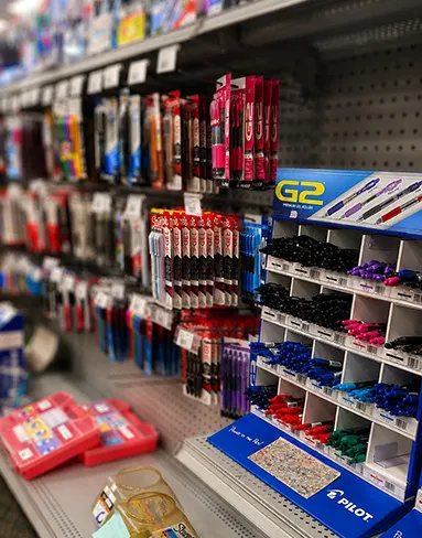 Pens, markers, and assorted school supplies on store shelf